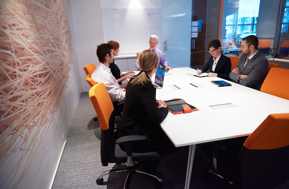 Business Team Seated Around Meeting Table in Modern Office