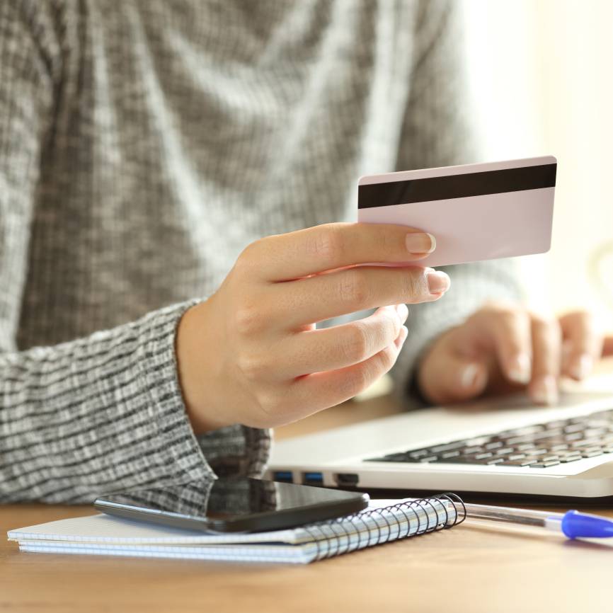 Close Up of Laptop Computer with Credit Card in Hands