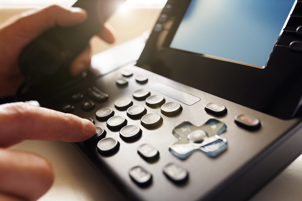 Close Up Hands Dialing VoIP Phone
